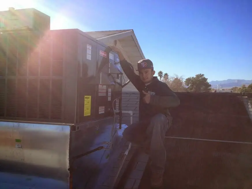 HVAC technician performing Air Duct Cleaning on a rooftop unit in New Haven